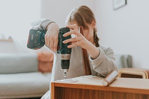 Person using drill to put assemble furniture