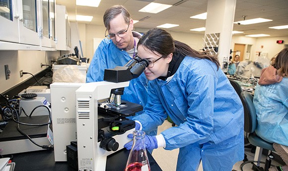 Student in a microbiology lab with instructor